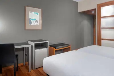 a bedroom with a bed and a desk and a bed sidx sidx sidx at AC Hotel Ponferrada by Marriott in Ponferrada