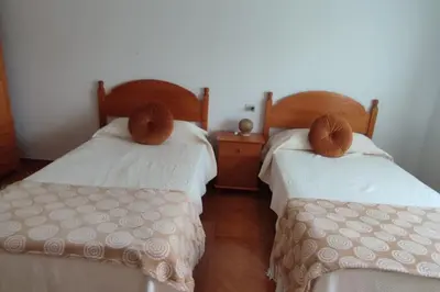 a bedroom with two beds and a dresser at Casa da Buxeira . Entorno magico. in Caritel