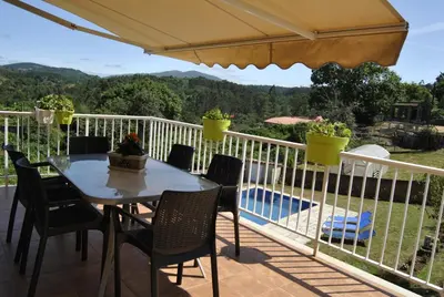 a table and chairs on a balcony with a view at Casa da Buxeira . Entorno magico. in Caritel