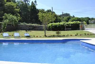 a swimming pool with two chairs and a yard at Casa da Buxeira . Entorno magico. in Caritel