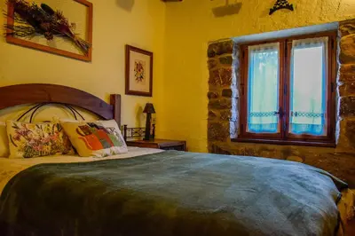 a bedroom with a bed and a window at Posada El Rincón de Babia in La Cueta