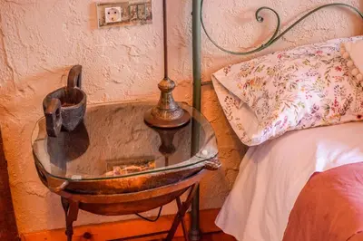 a glass table with a lamp on it next to a bed at Posada El Rincón de Babia in La Cueta