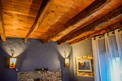 a room with a wooden ceiling with lights and a window at Posada El Rincón de Babia in La Cueta