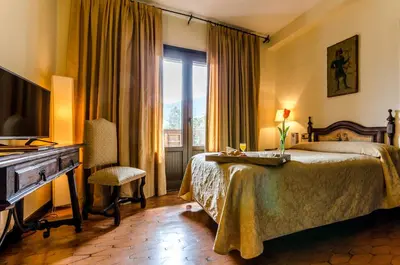 a hotel room with a bed and a desk and a television at Hotel Temple Ponferrada in Ponferrada