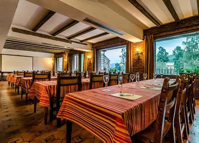 a dining room with tables and chairs and windows at Hotel Temple Ponferrada in Ponferrada