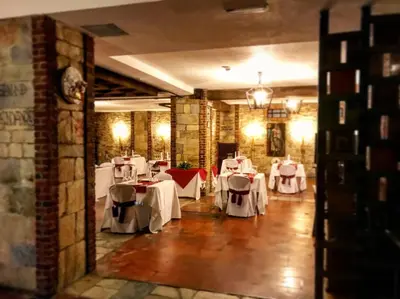 a restaurant with white tables and chairs in a room at Hotel Temple Ponferrada in Ponferrada