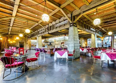a restaurant with red chairs and tables in a building at Hotel Temple Ponferrada in Ponferrada