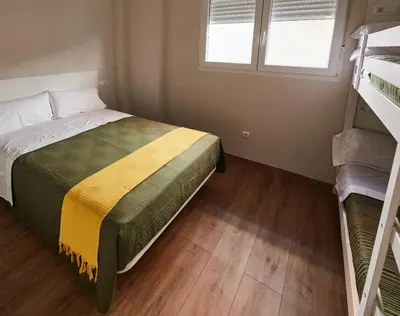a bedroom with a bed and two bunk beds at A Estreliña in Sigüeiro