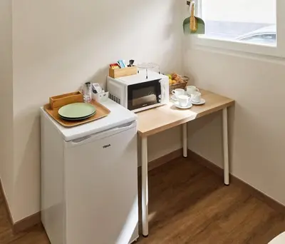 a small kitchen with a table with a microwave at A Estreliña in Sigüeiro