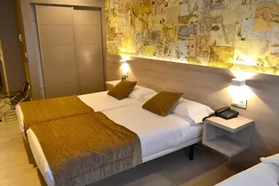 a hotel room with two beds and a map on the wall at Hotel Alda San Carlos in Santiago de Compostela