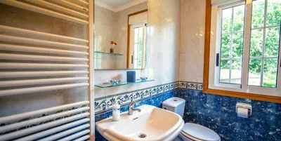 a bathroom with a sink and a toilet and a window at Casa Olivar El Mandarino in Orazo