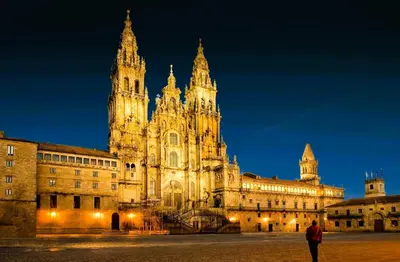 a large building with a clock tower at night at Casa Olivar El Mandarino in Orazo