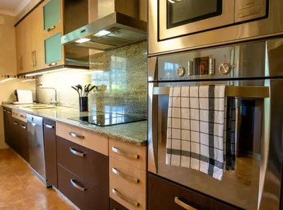 a kitchen with stainless steel appliances and wooden cabinets at Casa Olivar El Mandarino in Orazo