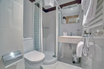 a white bathroom with a toilet and a sink at PR Rosa Rosae in Santiago de Compostela