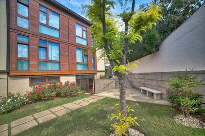 a building with a tree and a bench in a yard at PR Rosa Rosae in Santiago de Compostela
