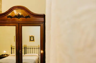 a bedroom with a wooden bed frame and a mirror at Pazo Almuzara in Boborás