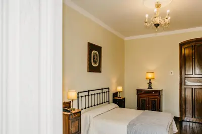 a bedroom with a bed and a chandelier at Pazo Almuzara in Boborás