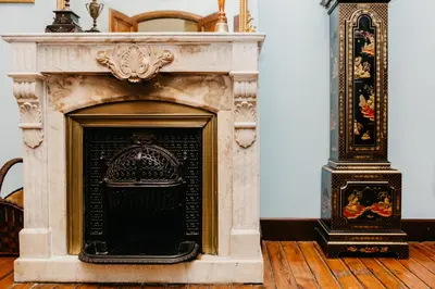 a stone fireplace in a room with wooden floors at Pazo Almuzara in Boborás