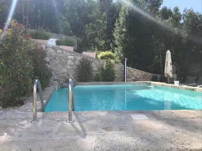 a swimming pool in a yard with a stone wall at Villa - 5 Bedrooms with WiFi - 7841 in A Estrada