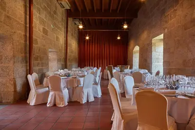a room with tables and chairs with white tablecloths at Eurostars Monumento Monasterio de San Clodio Hotel in Leiro