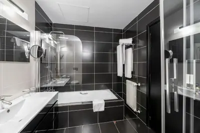 a black and white bathroom with a sink and a tub at Eurostars Monumento Monasterio de San Clodio Hotel in Leiro