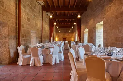 a banquet hall with white tables and chairs at Eurostars Monumento Monasterio de San Clodio Hotel in Leiro
