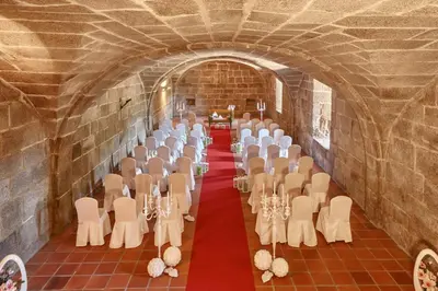 a room with a row of tables and chairs in a tunnel at Eurostars Monumento Monasterio de San Clodio Hotel in Leiro