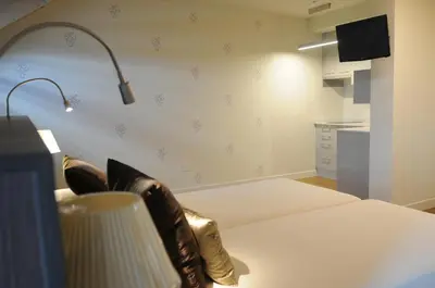 a room with a bed with boots on it at Guiana Rooms & Suites in Ponferrada