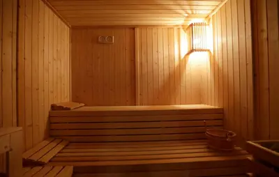 a sauna with a bench in a wooden room at Hotel Spa Congreso in Teo
