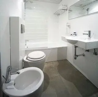 a white bathroom with a toilet and a sink at Hotel Spa Congreso in Teo