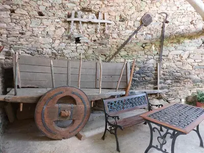 a wooden bench next to a stone wall with a table at Casas de Maragouzos in Silleda