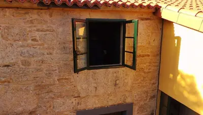a window on the side of a brick building at Casas de Maragouzos in Silleda