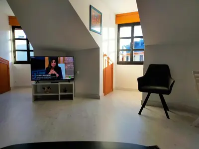 a living room with a television and a chair at Apartamento en el casco antiguo de Ponferrada in Ponferrada