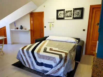 a bedroom with a bed with a striped blanket on it at Apartamento en el casco antiguo de Ponferrada in Ponferrada