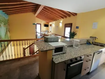 a kitchen with a counter top with a microwave at PENSIÓN RÚSTICA SANTA MARIÑA DA PONTE in Santa Marina del Puente