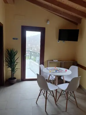 a room with a table and chairs and a balcony at PENSIÓN RÚSTICA SANTA MARIÑA DA PONTE in Santa Marina del Puente