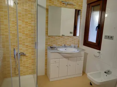 a bathroom with a sink and a shower and a toilet at PENSIÓN RÚSTICA SANTA MARIÑA DA PONTE in Santa Marina del Puente