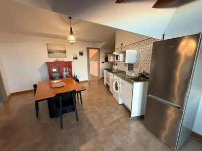 a kitchen with a wooden table and a refrigerator at A Marola By Oktheway in Puentedeume