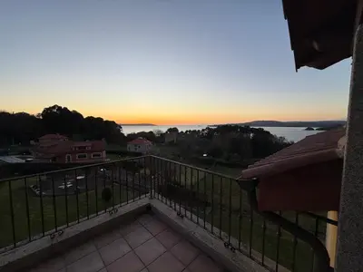 a view of the sunset from the balcony of a house at A Marola By Oktheway in Puentedeume