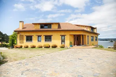 a large yellow house with a large driveway at A Marola By Oktheway in Puentedeume