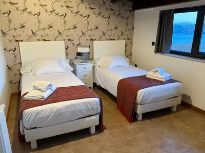 a room with two beds and a window at A Marola By Oktheway in Puentedeume