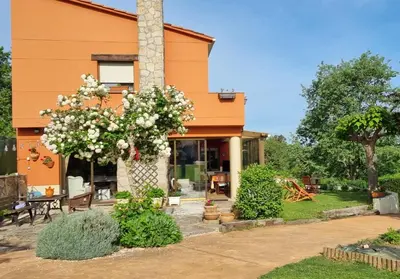 an orange house with white flowers in front of it at leiradaporta in Monforte de Lemos