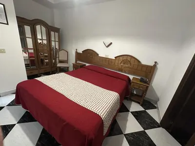 a bedroom with a bed and a checkered floor at Hotel Mediante in Ribadeo