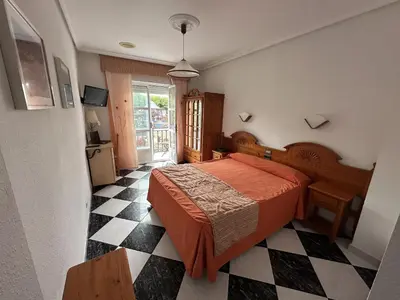 a bedroom with a bed and a checkered floor at Hotel Mediante in Ribadeo