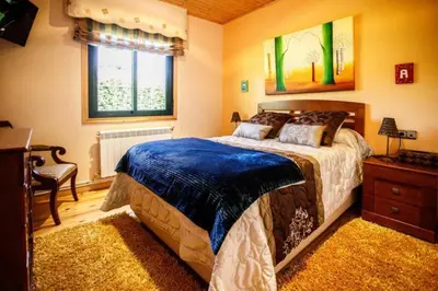 a bedroom with a large bed and a window at Villacambote5 in Lalín