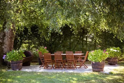 a wooden table and chairs under a tree at Villacambote5 in Lalín