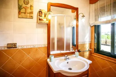 a bathroom with a sink and a mirror and a window at Villacambote5 in Lalín