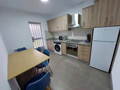 a kitchen with a table and a white refrigerator at Acea Nova 3 in Monforte de Lemos