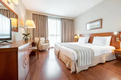 a hotel room with a bed and a flat screen tv at Eurostars San Lazaro in Santiago de Compostela