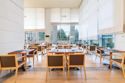 a dining room with wooden tables and chairs at Eurostars San Lazaro in Santiago de Compostela
